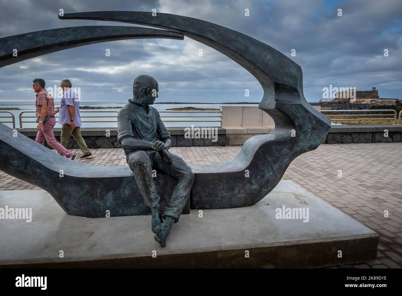 `La Mirada de Cesar´ Denkmal für Cesar Manrique von Manolo Gonzalez, Promenade, Arrecife, Lanzarote, Spanien. Im Botton rechts Saint Gabriel Castle Stockfoto